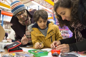 A child and parents with a circuit board