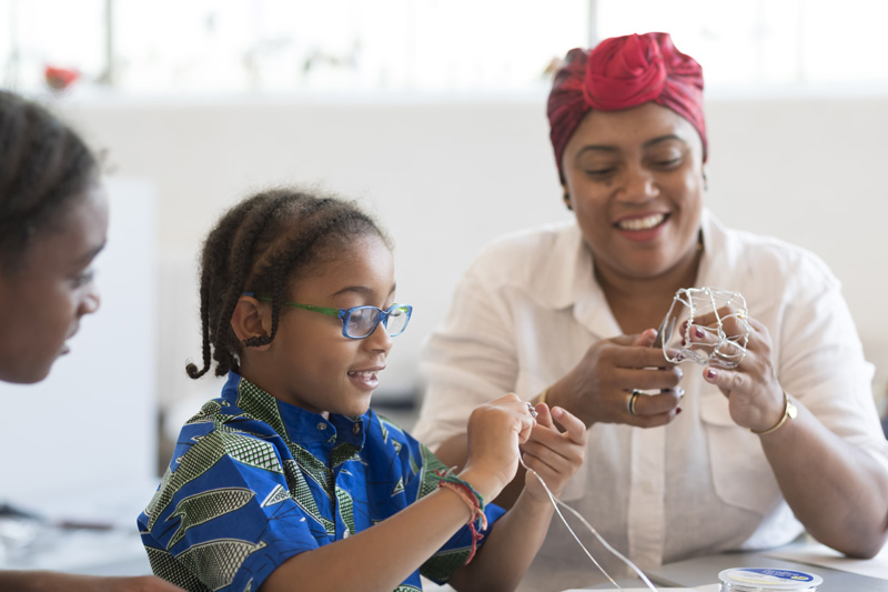 A mother and her child constructing with wire