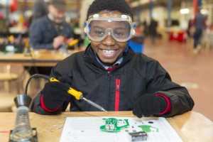 A boy with a soldering kit