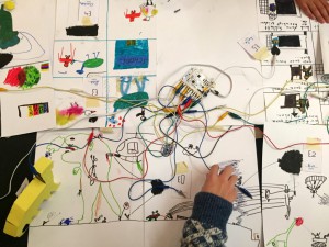A child playing with crafts and a circuit board