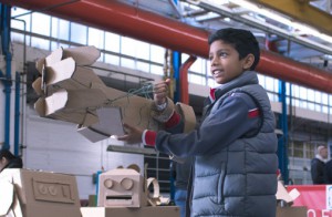 A child with a cardboard robot arm