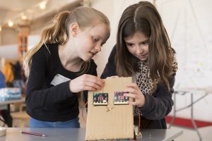 two girls making a robot cat